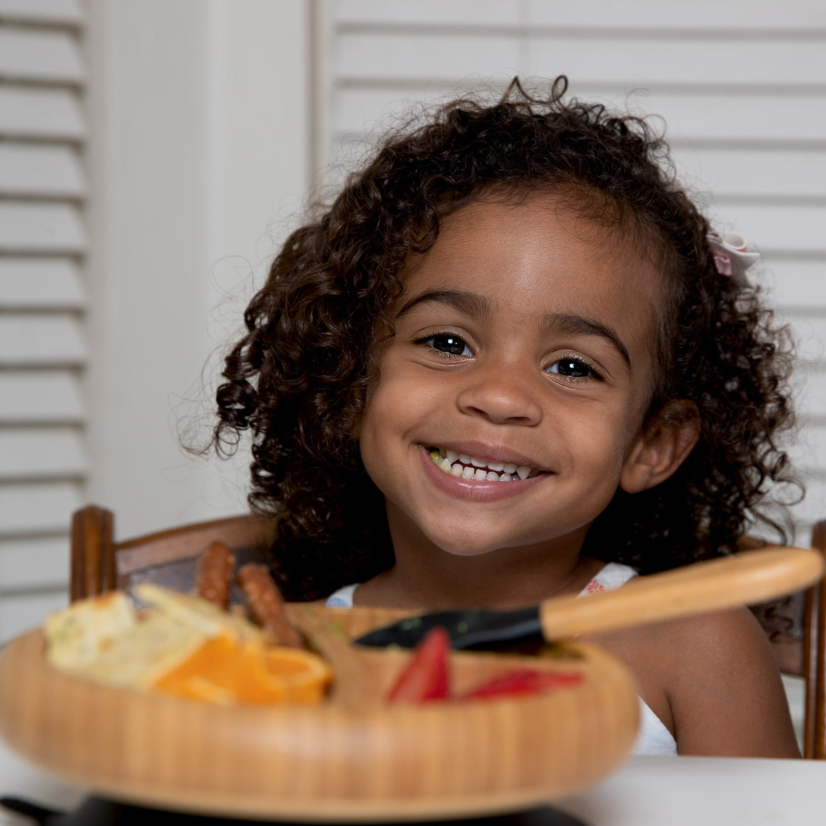 Child enjoying a meal from an Avanchy bamboo divided plate